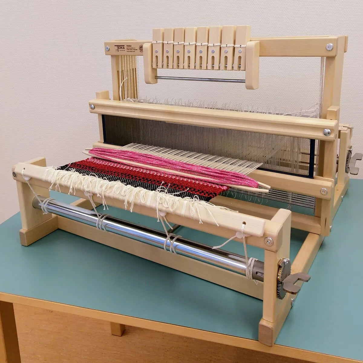 Toika Leena Webstuhl mit 8 Schäften – Frontalansicht mit Webstück