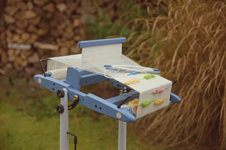 Kromski Presto Webrahmen in Blau beim Weben auf Stativ mit Garn und Gewebe