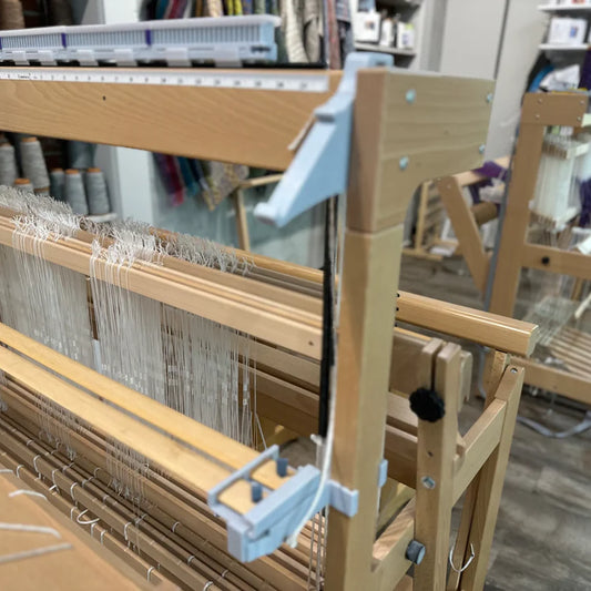 LoftyFiber Helping Hands am Louet Spring Webstuhl – Seitenansicht mit montierten Halterungen und weißem Kettgarn im Webshop