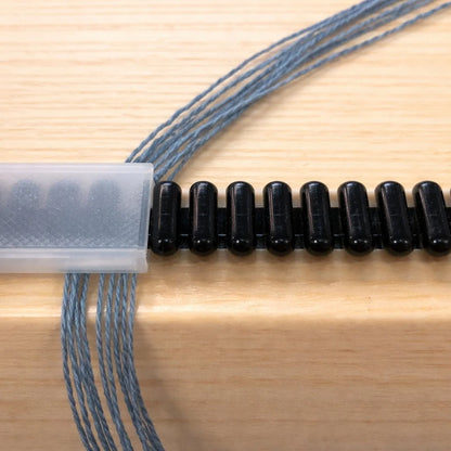 Detailaufnahme der LoftyFiber Reedekamm Abdeckung auf Louet Reedekamm mit gesicherten Kettfäden