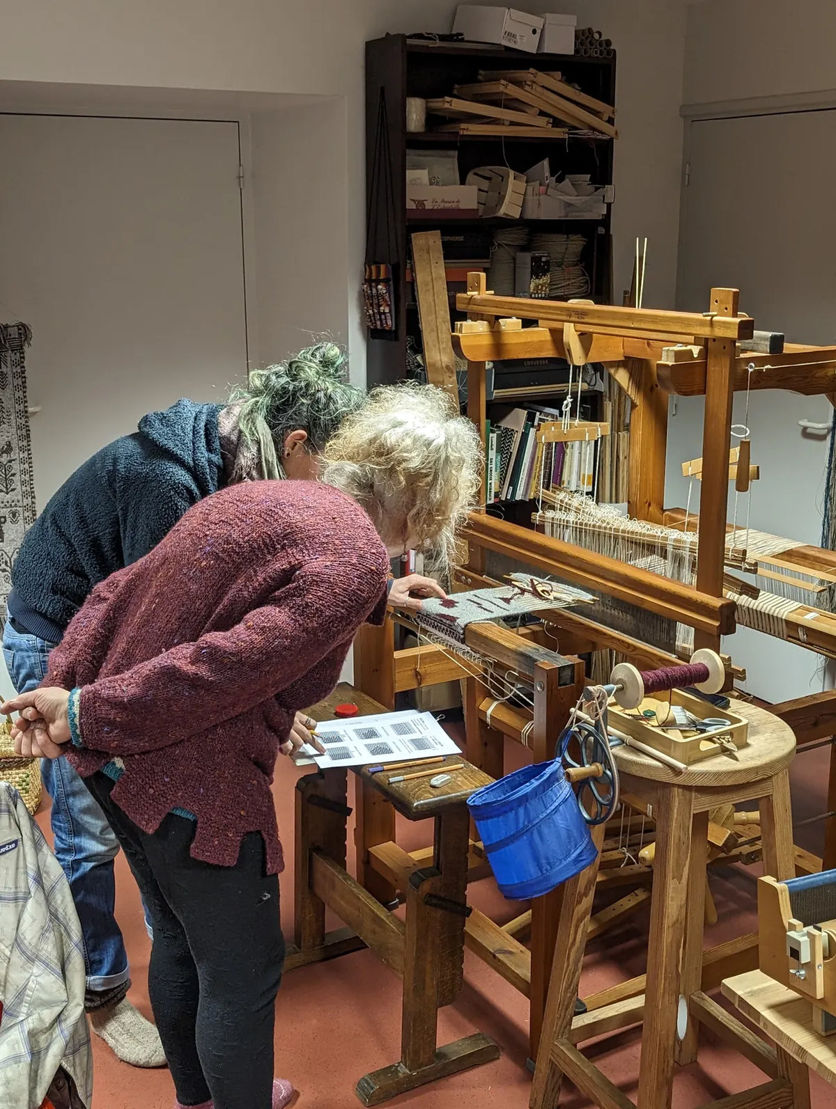 Programme individuel : la formatrice conseille une stagiaire devant un métier à tisser à l'Atelier La Trame