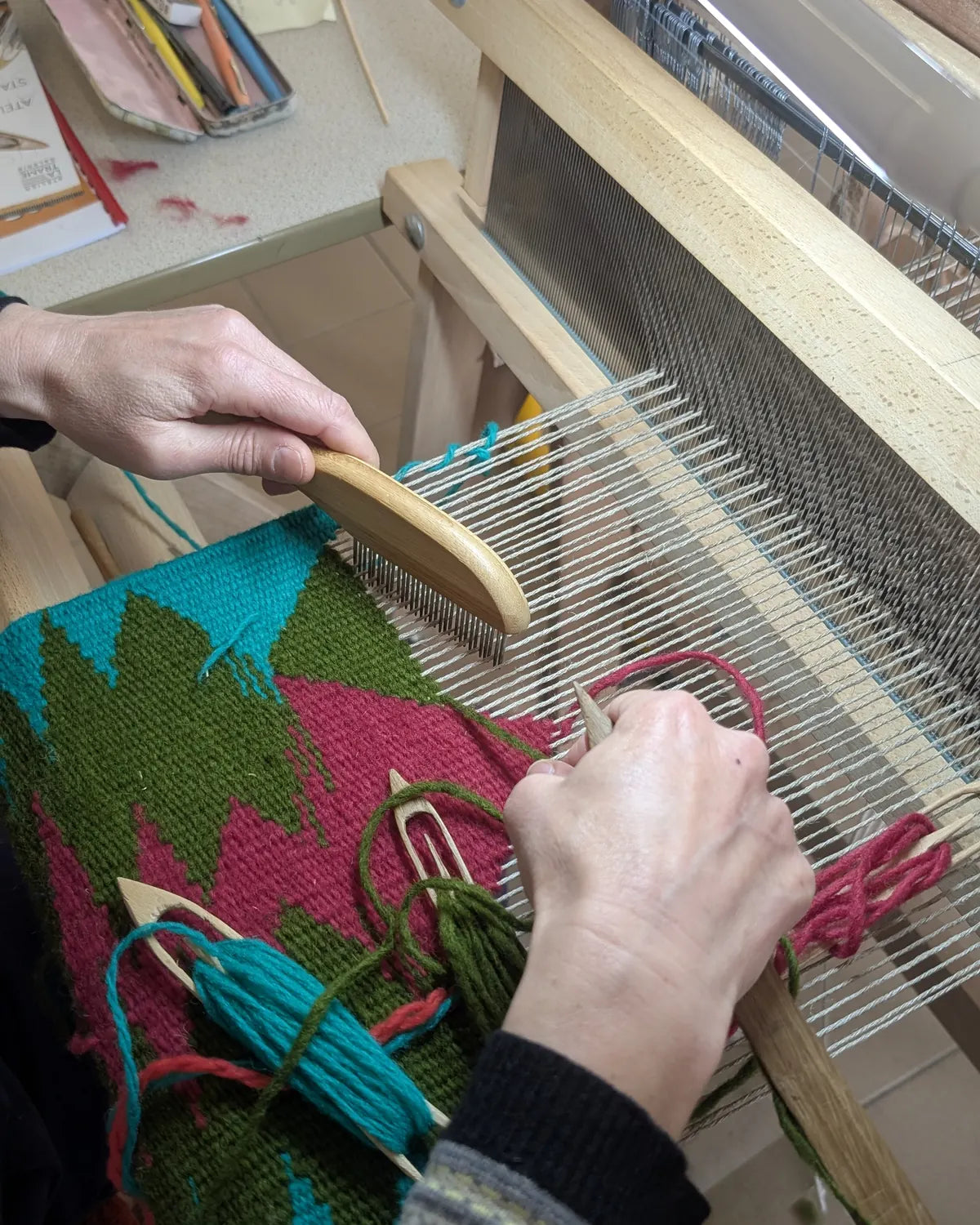 Tissage à motifs en zigzag rose, vert et turquoise sur métier à tisser, stage wedge weave