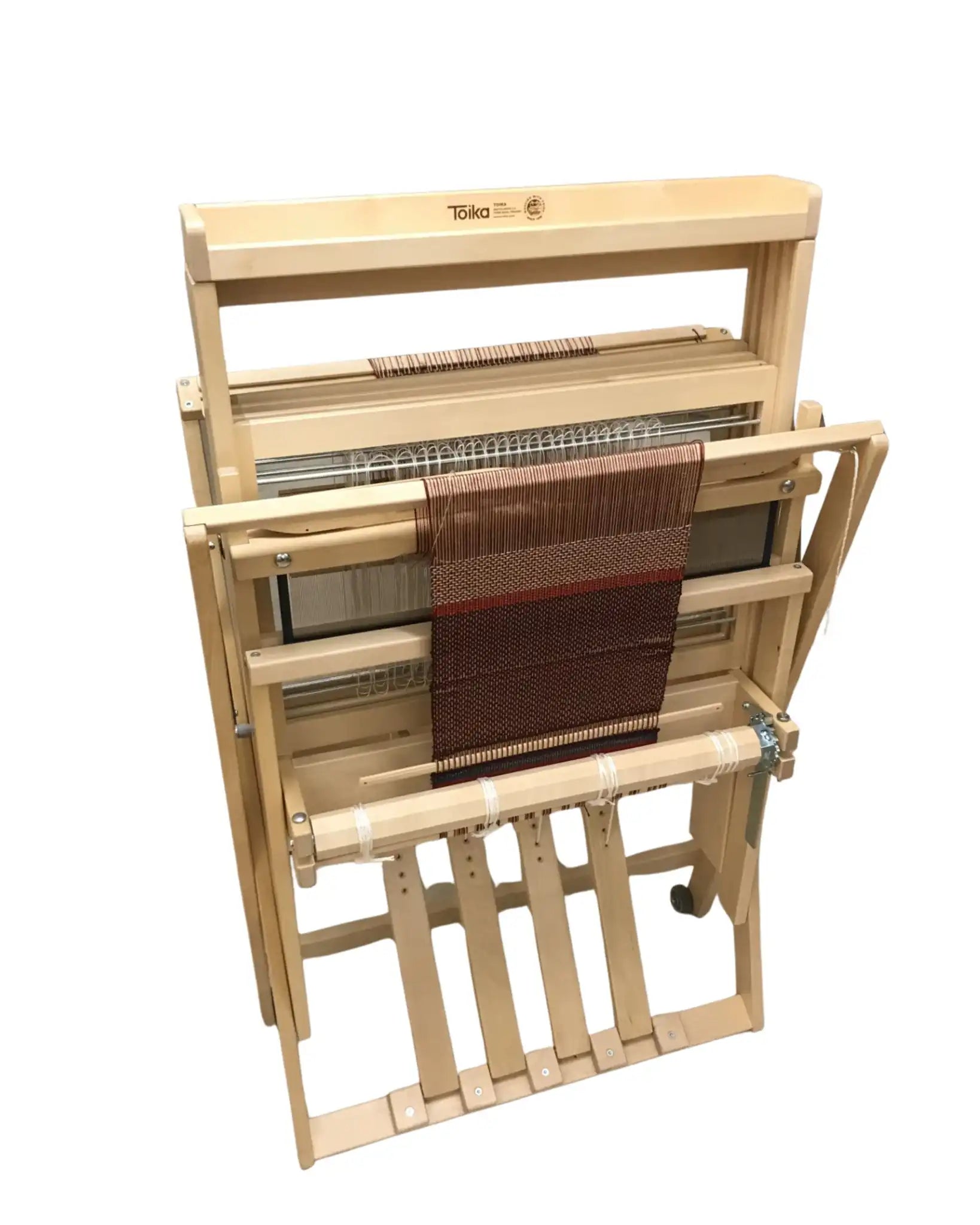 Toika Anni Bodenwebstuhl – kompakte Ansicht des Vier-Schaft-Webstuhls aus Holz mit Gewebe auf dem Warenbaum, ideal für platzsparendes Weben